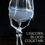Purple cocktail in skeleton glass, marshmallow strands over glass